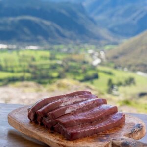 Filetes de hígado de ternera fresco presentados sobre una tabla de madera en el Pirineo